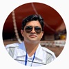rajdeep in front of a ship on dry dock wearing sunglasses