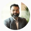 a bearded man in a suit is smiling
